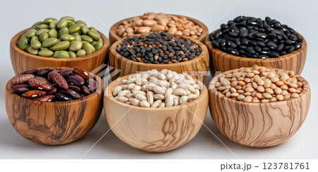 Wooden bowls filled with various grains, legumes, and beans on white background 123781761