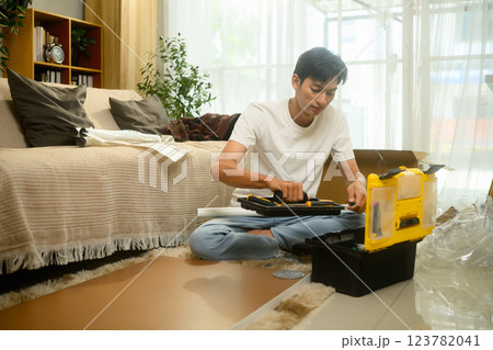 Young asian man checking the assembly guide before for new furniture Young asian man checking the assembly guide before for new furniture 123782041