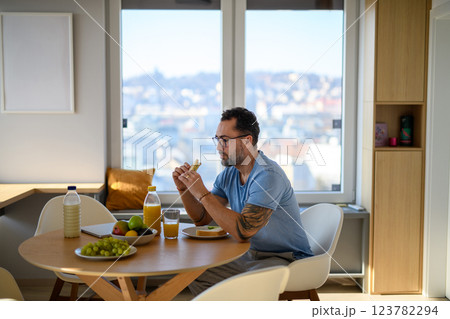 Diabetic man with CGM sensor having healthy breakfast. Diabetic man with CGM sensor having healthy breakfast. 123782294