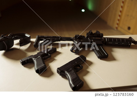 Pistols and assault weapons at shooting range used to train and test soldiers on necessary combat skills. Rifles and handguns to be used by army soldiers training to enhance combat readiness 123783160