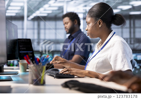 Woman in data center workspace running system diagnostic tests on PC to fix problems. African american employee deploying and error checking utilities on computer to fix network issues performance 123783178