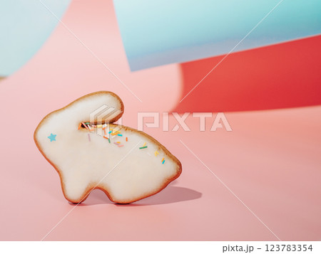 Easter bunny cookie on pink and blue curved paper pastel background with shadows. Happy Easter Day concept. Minimal Easter concept. Copy space. Easter cooking baking background. Easter bunny cookie on pink and blue curved paper pastel background with shadows. Happy Easter Day concept. Minimal Easter concept. Copy space. Easter cooking baking background. 123783354