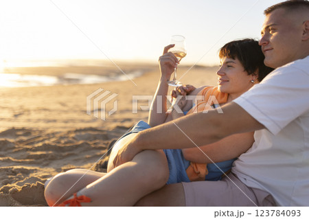 Couple enjoying wine on beach at sunset: romantic getaway Couple enjoying wine on beach at sunset: romantic getaway 123784093