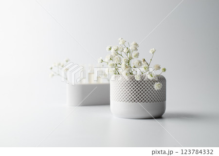 Small white vase decorated with artificial flowers Small white vase decorated with artificial flowers 123784332