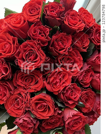 Woman holding luxury bouquet of fresh red roses on light background, closeup Natural background Woman holding luxury bouquet of fresh red roses on light background, closeup Natural background 123784798