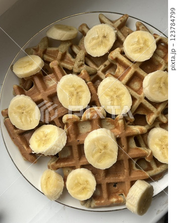 large plate on a white table with, freshly bake round waffles with a banana healthy breakfast sweet large plate on a white table with, freshly bake round waffles with a banana healthy breakfast sweet 123784799