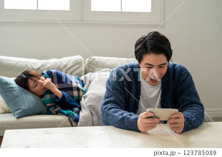 スマホに夢中で看病しない男性 スマホに夢中で看病しない男性 123785089