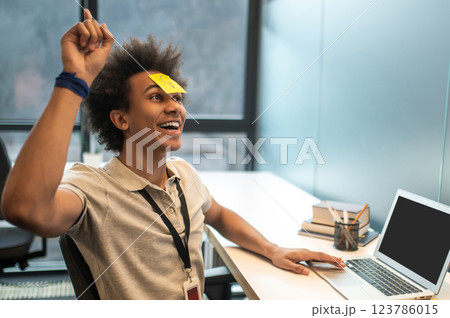 Businessman with yellow sticker on his face in modern office 123786015