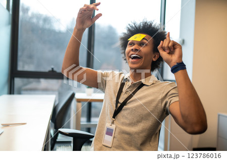Man with yellow notes on face having fun in office 123786016