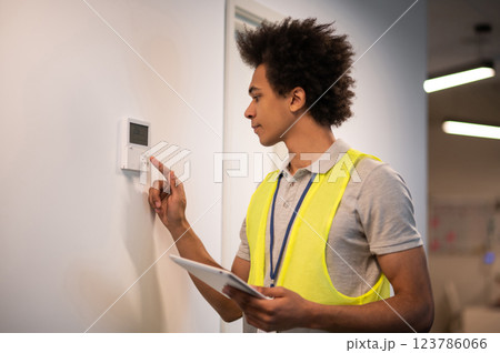 Service man checking the sensor door locker and looking involved Service man checking the sensor door locker and looking involved 123786066