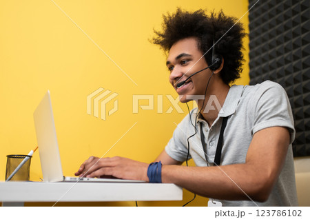 Young man sitting at the laptop and talking to the client online 123786102