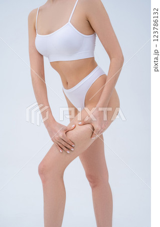 Close up picture of a woman in white lingerie making cellulite self-test 123786132