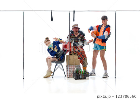 Homeless man extending bread toward student while young athlete stands nearby holding basketball against white studio background. 123786360