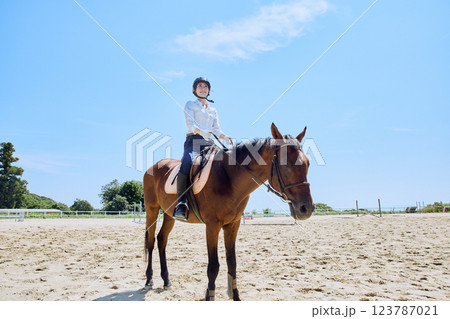馬に乗って乗馬の練習をする女性 123787021