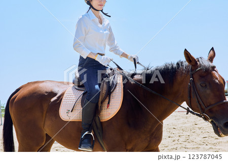 馬に乗って乗馬の練習をする女性 123787045