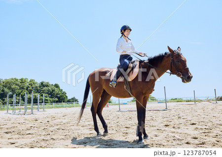 馬に乗って乗馬の練習をする女性 123787054