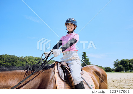 馬に乗って乗馬の練習をする女性 123787061