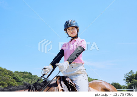 馬に乗って乗馬の練習をする女性 123787066