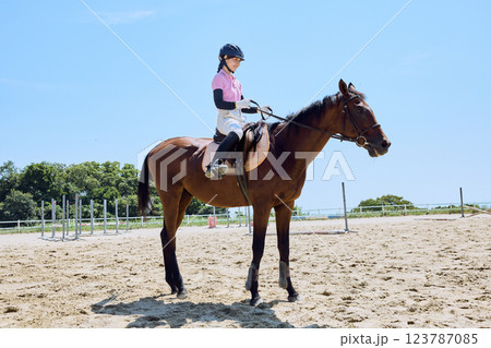 馬に乗って乗馬の練習をする女性 123787085
