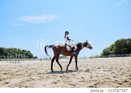 馬に乗って乗馬の練習をする女性 123787107