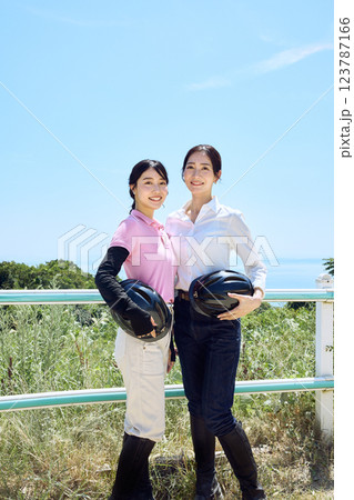 乗馬クラブでヘルメットを持ってたたずむ女性 123787166
