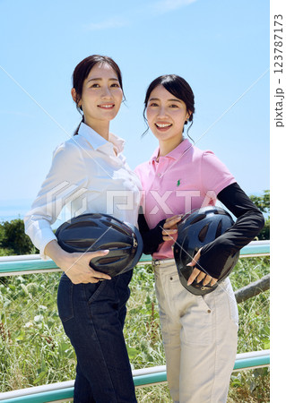 乗馬クラブでヘルメットを持ってたたずむ女性 乗馬クラブでヘルメットを持ってたたずむ女性 123787173