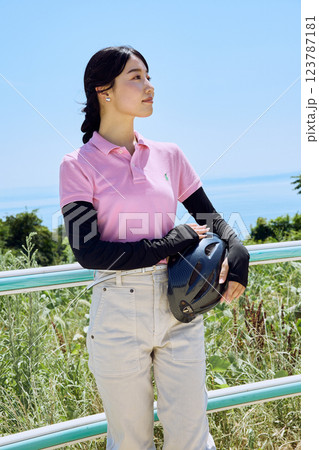 乗馬クラブでヘルメットを持って空を見上げる女性 123787181