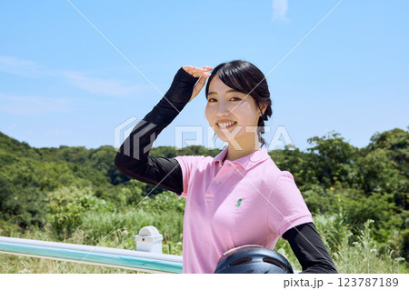 乗馬クラブでヘルメットを持ってたたずむ女性 乗馬クラブでヘルメットを持ってたたずむ女性 123787189