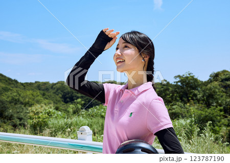 乗馬クラブでヘルメットを持って空を見上げる女性 123787190