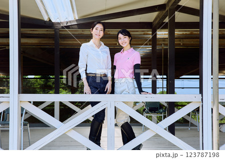 乗馬クラブのテラスから馬場を見る女性 123787198