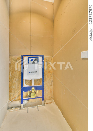 A partially finished bathroom showcasing bare walls, plumbing fixtures, and construction materials, highlighting renovation work in progress. 123787970