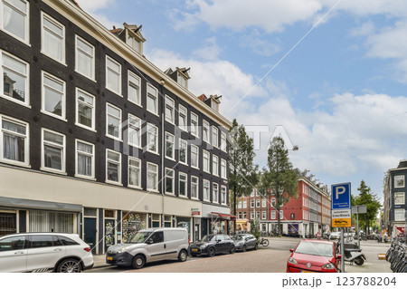 A picturesque street view featuring charming buildings, greenery, and urban life in Amsterdam. The combination of architecture and nature creates a lively atmosphere. A picturesque street view featuring charming buildings, greenery, and urban life in Amsterdam. The combination of architecture and nature creates a lively atmosphere. 123788204