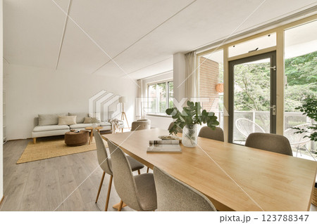 A stylish and cozy living room featuring modern furniture, large windows, and natural light, creating an inviting atmosphere for relaxation and gathering. 123788347