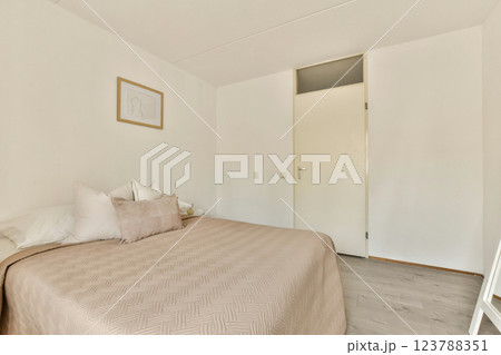 A serene and minimalistic bedroom featuring a soft color palette, simple decor, and natural light. The design emphasizes comfort and tranquility in a modern space. 123788351