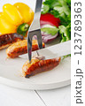 Grilled sausages with vegetables and herbs on a light background 123789363
