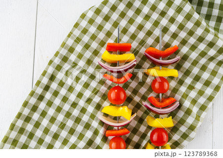 Vegetable kebab on skewers on a light wooden background Vegetable kebab on skewers on a light wooden background 123789368