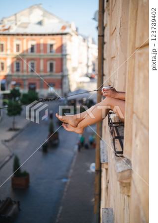 Close-up of female legs with red shoes of high heels. The woman is raising her feet through the window Close-up of female legs with red shoes of high heels. The woman is raising her feet through the window 123789402