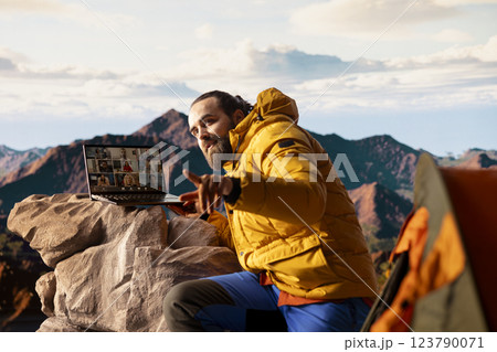 Adventure seeker having internet everywhere and using video call discussion, chatting with colleagues on the top of the mountain. Hiker with a technology obsession and dependency. 123790071