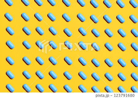 Blue pills in rows on yellow background, creative layout. 123791680