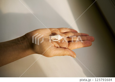 Open hand holding small seashell in sunlight Open hand holding small seashell in sunlight 123791684