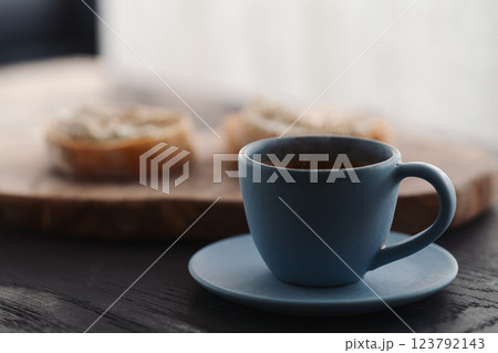 Espresso in blue cup with sandwiches with cream cheese on background Espresso in blue cup with sandwiches with cream cheese on background 123792143