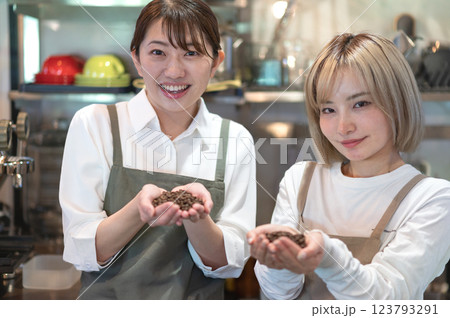 コーヒー豆を持つエプロン姿の2人の女性 コーヒー豆を持つエプロン姿の2人の女性 123793291