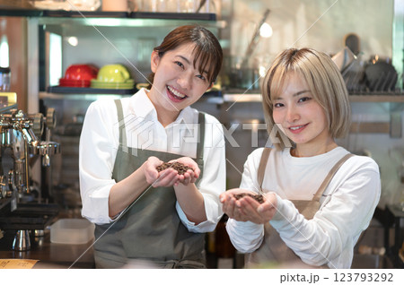 コーヒー豆を持つエプロン姿の2人の女性 123793292