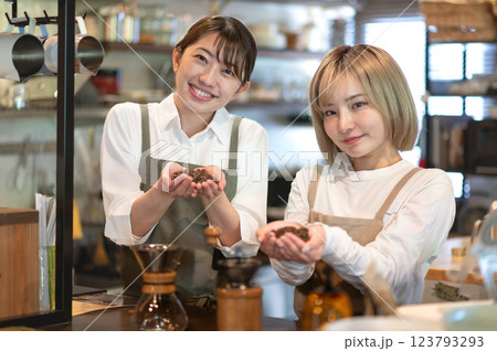 コーヒー豆を持つエプロン姿の2人の女性 コーヒー豆を持つエプロン姿の2人の女性 123793293