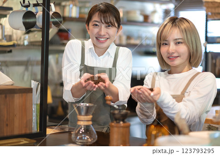 コーヒー豆を持つエプロン姿の2人の女性 コーヒー豆を持つエプロン姿の2人の女性 123793295
