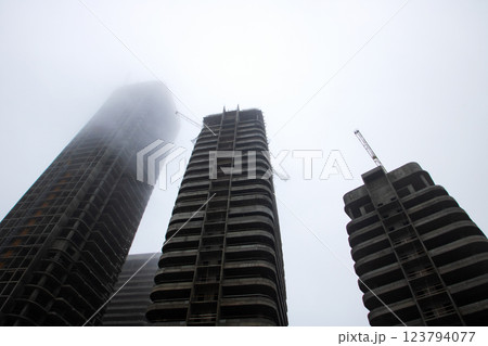 Looking up at a tall building that prominently displays the letter f on it 123794077