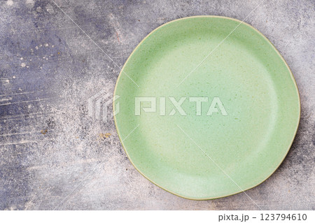 Green plate is on grey surface 123794610