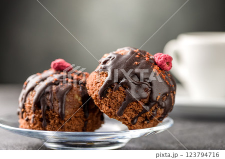 Round chocolate cakes. Decorated with candied raspberries. Dark background 123794716