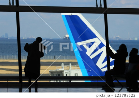 羽田空港第2ターミナル国際線エリアから滑走路を眺める利用客　滑走路を眺める利用客のシルエット 123795522