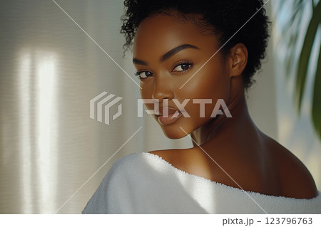 woman with curly hair looks back over her shoulder, showcasing her radiant skin and natural beauty in soft lighting. serene atmosphere enhances her graceful expression woman with curly hair looks back over her shoulder, showcasing her radiant skin and natural beauty in soft lighting. serene atmosphere enhances her graceful expression 123796763